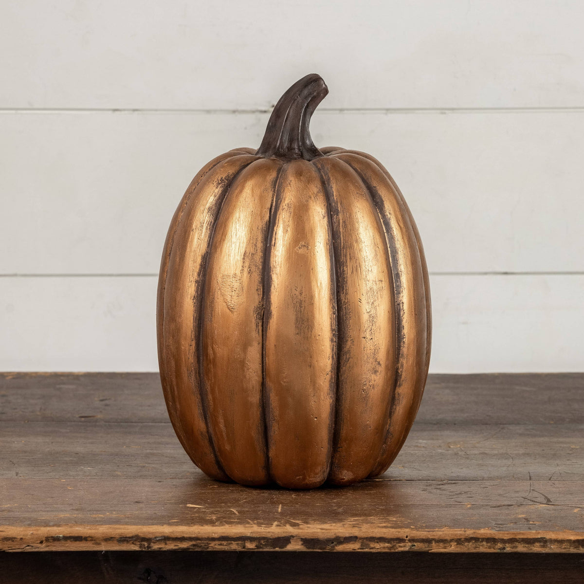 Gold tall pumpkin on a wooden table